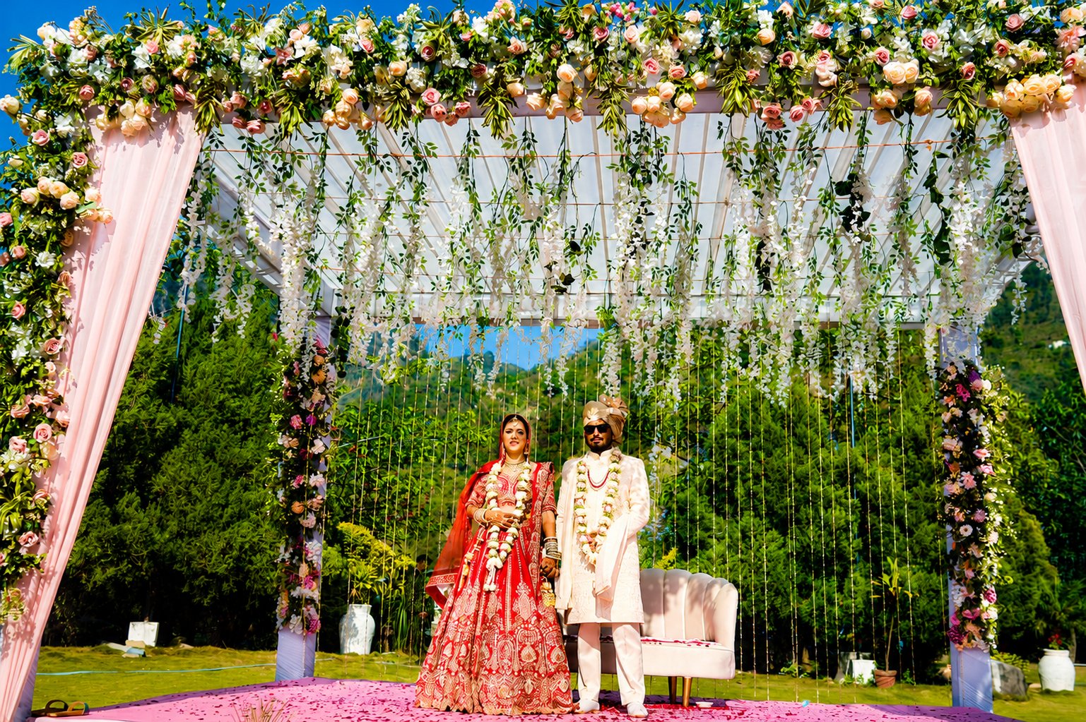 A wedding couple beneath a canopy of flowers